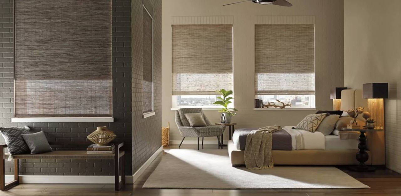Hunter Douglas woven wood shades blocking light in a bedroom near Lee County, FL